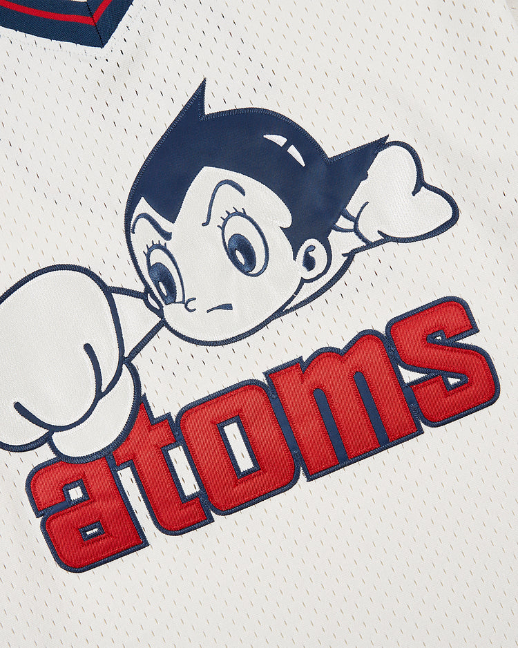 Close-up of a white mesh fabric on the Sankei Atoms Mesh V-Neck Jersey by Ebbets Field, featuring Astro Boy with spiked hair and large eyes flying above bold red 