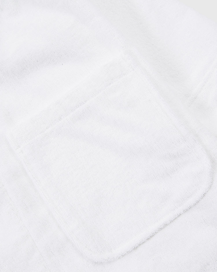 Close-up of the Ebbets Field Muhammad Ali Cotton Terry Boxing Robe, highlighting its soft white terry fabric and a single rectangular patch pocket—echoing classic Ali training robe style with visible texture and stitching details.