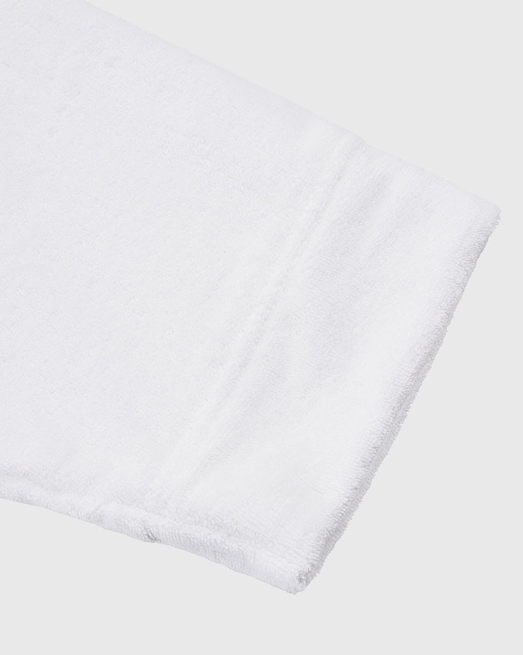 A close-up of the Ebbets Field Muhammad Ali Cotton Terry Boxing Robe, folded to showcase its subtle stitched border, reminiscent of classic boxing apparel, against a plain light background.