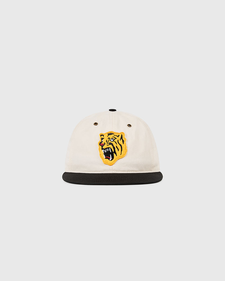 The Osaka Tigers Cotton Twill Ballcap by Ebbets Field is a white cap with a black brim and yellow tiger head embroidery, blending classic Japanese baseball style with the spirit of Koshien Field.