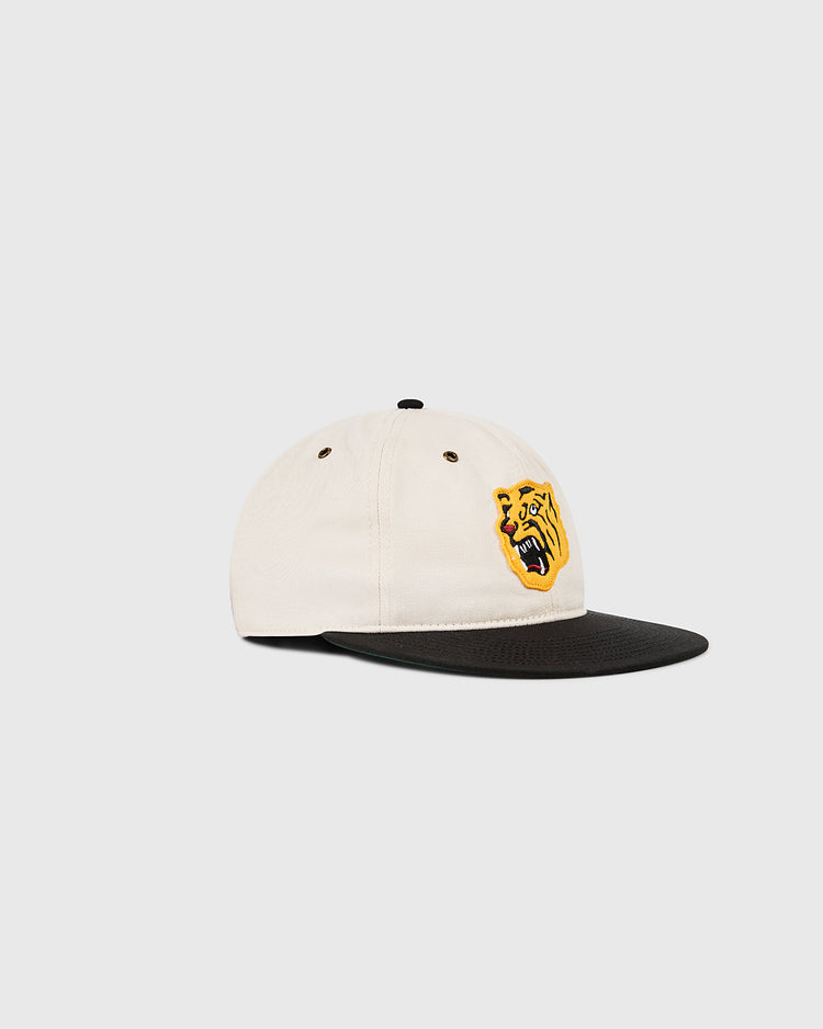 The Ebbets Field Osaka Tigers Cotton Twill Ballcap features a beige crown, black brim, and a yellow embroidered roaring tiger face on the front panel, shown against a plain light background.