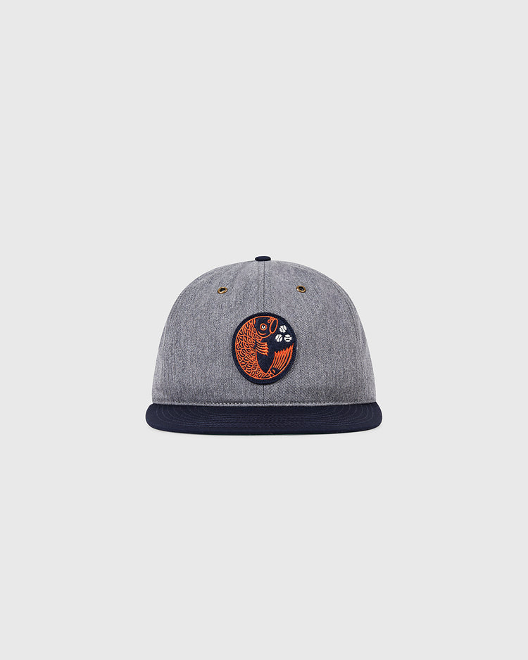 The Ebbets Field Hiroshima Carp Cotton Twill Ballcap is a grey cap with a black brim and an orange and black fish patch inspired by the Hiroshima Carp, shown here on a plain white background.