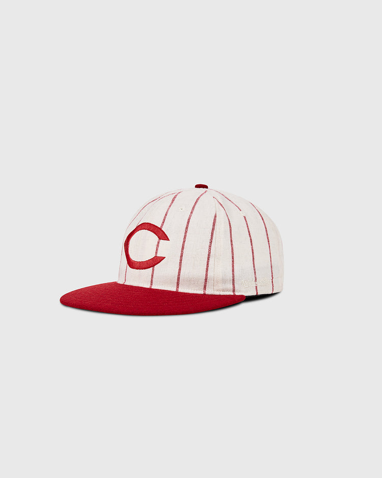 The Ebbets Field Cincinnati Reds 1958 MLB Authentic Wool Ballcap features thin red stripes, a bold red bill, and a large red C on the front. Shown on a plain light gray background. Part of the Decade of Change Collection.