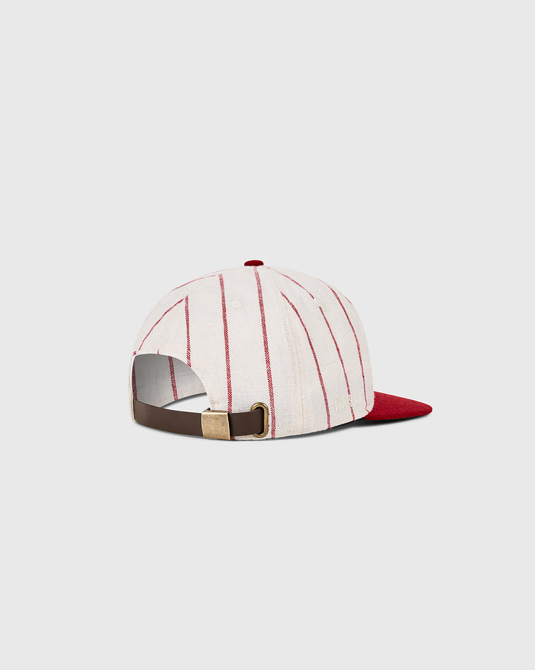 The Cincinnati Reds 1958 MLB Authentic Wool Ballcap by Ebbets Field features a white cap with vertical red stripes, a red brim, and an adjustable brown leather strap with a brass buckle, shown on a light gray background.