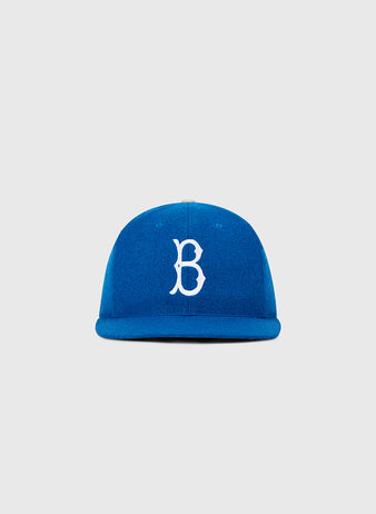 The Ebbets Field Brooklyn Dodgers 1955 MLB Authentic Wool Ballcap is blue with a white embroidered B on the front, inspired by the original on-field design, shown on a plain light gray background.