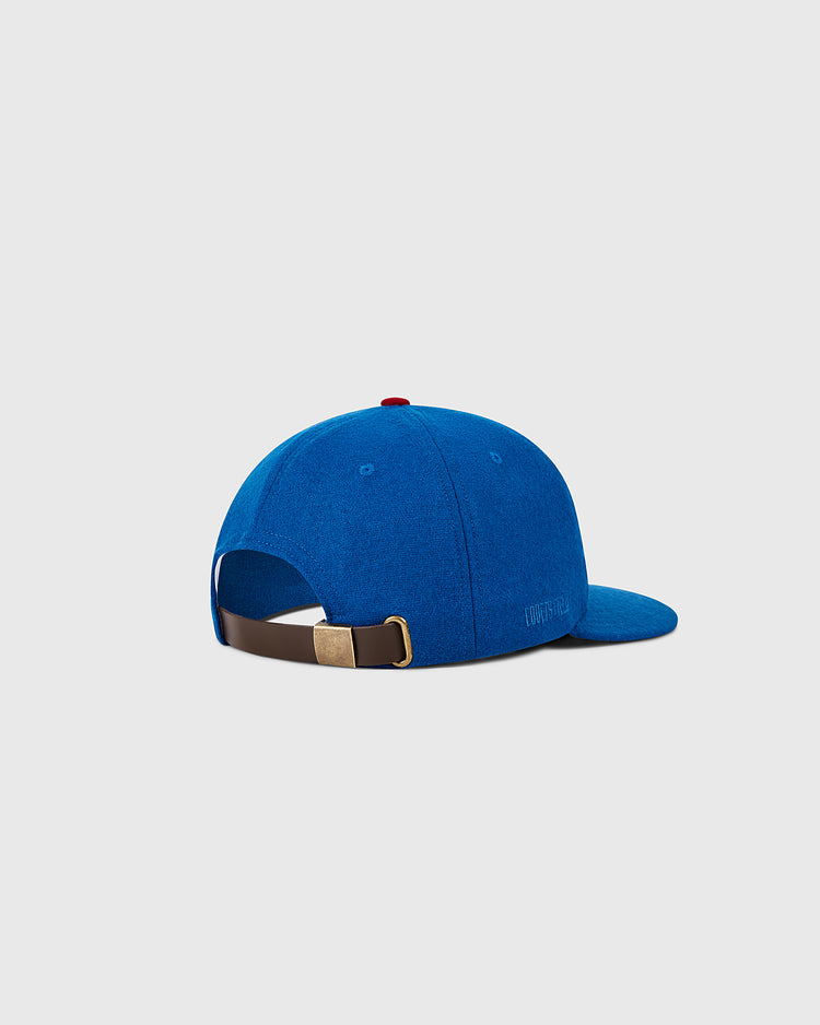 The Ebbets Field Chicago Cubs 1956 MLB Authentic Wool Ballcap is displayed from the back at an angle, showcasing a brown adjustable strap with a gold buckle, a small red top button, and a plain light gray background.