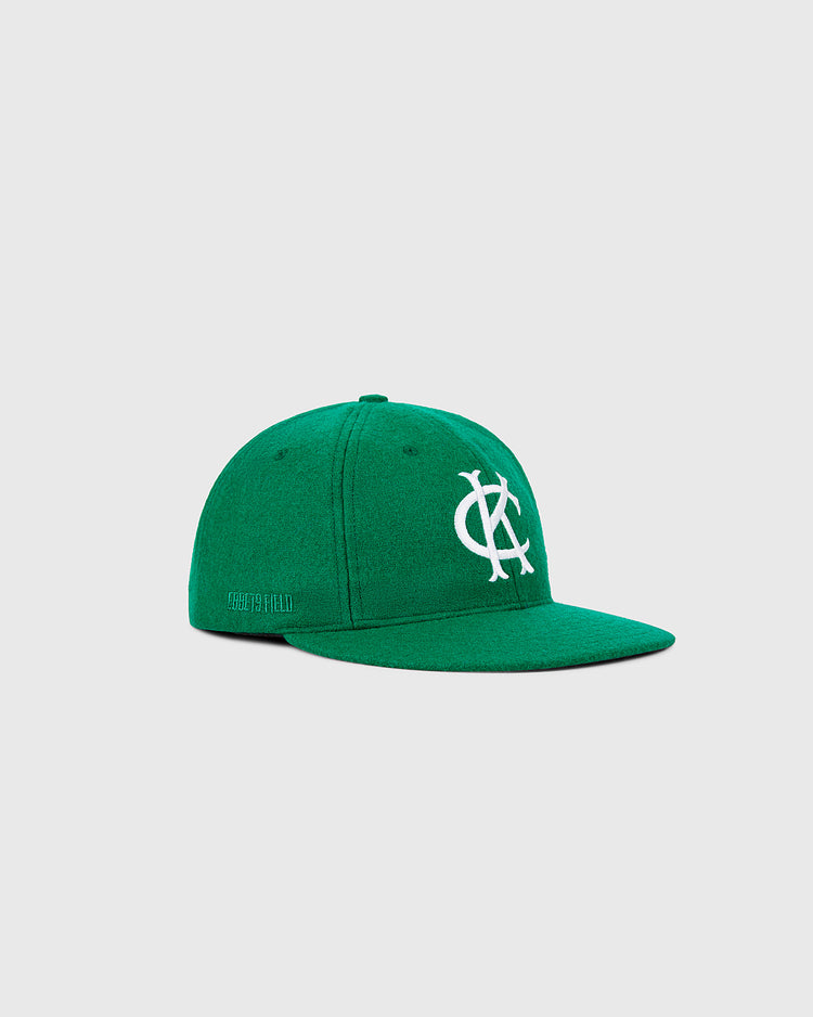 The Ebbets Field Kansas City Athletics 1963 MLB Authentic Wool Ballcap features a green crown with a white overlapping KC logo, inspired by the original team cap, and is shown on a light gray background.