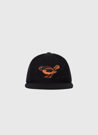 The Ebbets Field Baltimore Orioles 1954 MLB Authentic Wool Ballcap is a black cap with an orange bird embroidered on the front, shown against a plain light grey background.