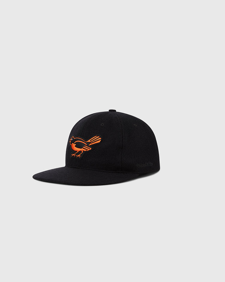 The Ebbets Field Baltimore Orioles 1954 MLB Authentic Wool Ballcap features a black design with an orange bird logo, shown on a light gray background. Part of the Decade of Change Collection, it's an authentic on-field cap.