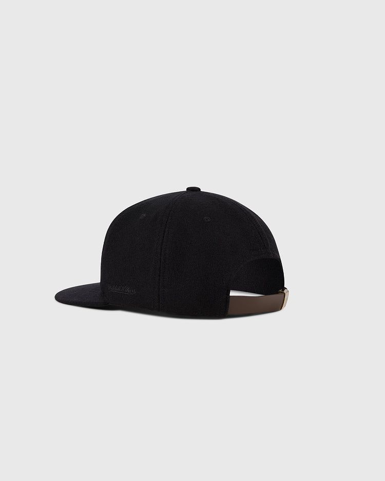 The Ebbets Field Baltimore Orioles 1954 MLB Authentic Wool Ballcap is shown from the back, featuring a black design with a brown adjustable strap and buckle. Inspired by the Decade of Change Collection, it's set against a plain light gray background.