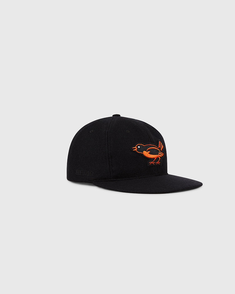 The Ebbets Field Baltimore Orioles 1954 MLB Authentic Wool Ballcap is a black on-field cap with an embroidered orange bird, inspired by the original 1954 design, shown on a plain light gray background.