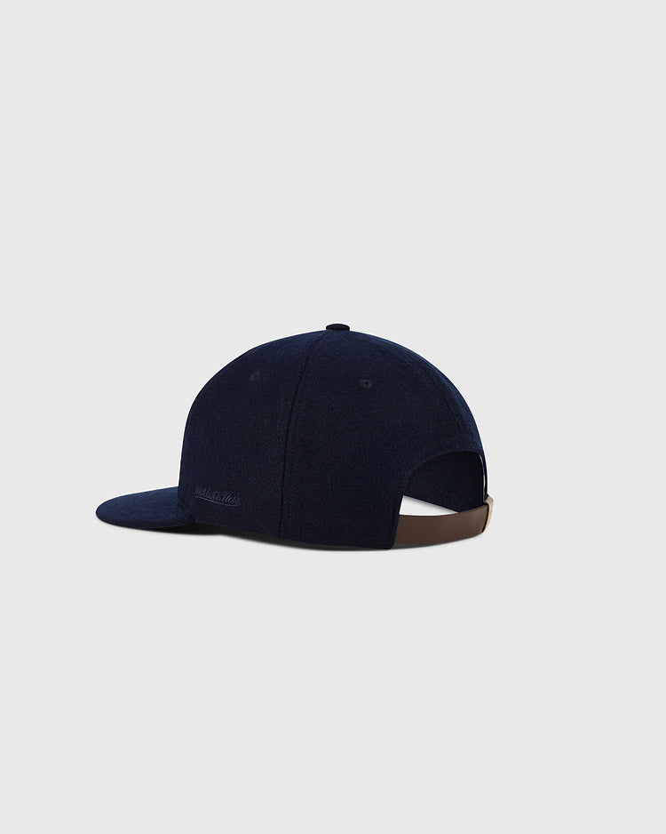 A navy blue Boston Red Sox 1955 MLB Authentic Wool Ballcap by Ebbets Field, shown from the back with a curved brim, brown adjustable strap, and top button. Part of the Decade of Change Collection, set on a light gray background.