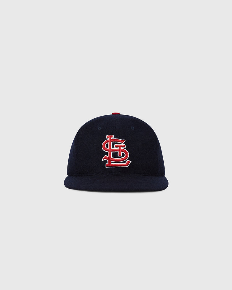 The Ebbets Field St. Louis Cardinals 1963 MLB Authentic Wool Ballcap features a navy design with a red and white interlocking STL logo, shown on a plain light gray background. Part of the Decade of Change Collection.