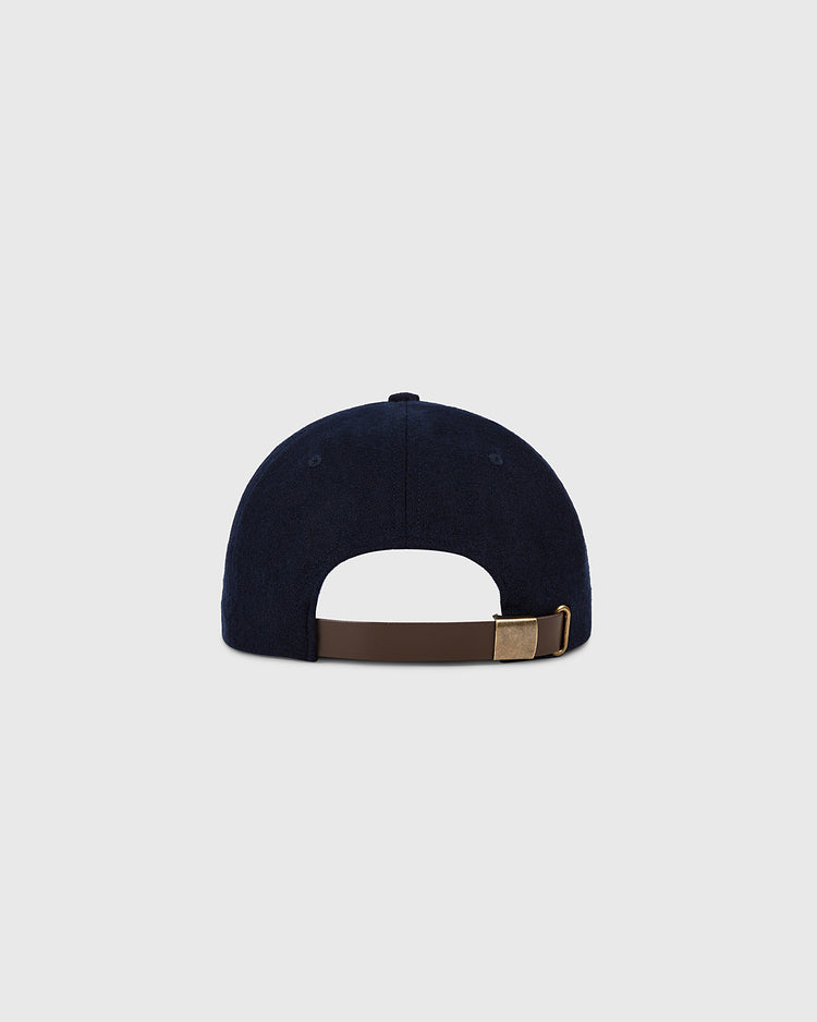 The Ebbets Field Cleveland Indians 1958-1961 Authentic Wool Ballcap, in navy blue, is shown from the back with a brown adjustable strap and metal clasp on a light gray background. Part of the Decade of Change Collection.