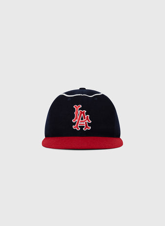 The Ebbets Field Los Angeles Angels 1961 MLB Authentic Wool Ballcap features navy blue wool, a red brim, and a white-and-red interlocking LA logo on the front, shown against a plain light gray background.