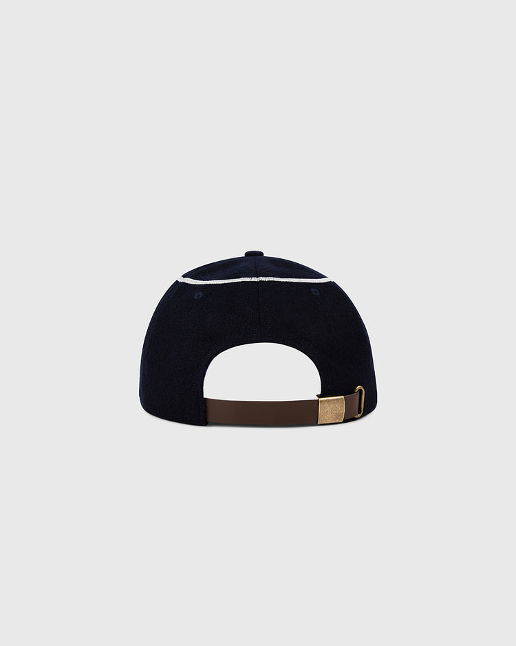 A back view of the Ebbets Field Los Angeles Angels 1961 MLB Authentic Wool Ballcap shows its navy wool, brown adjustable strap, and brass buckle, set against a plain light gray background.