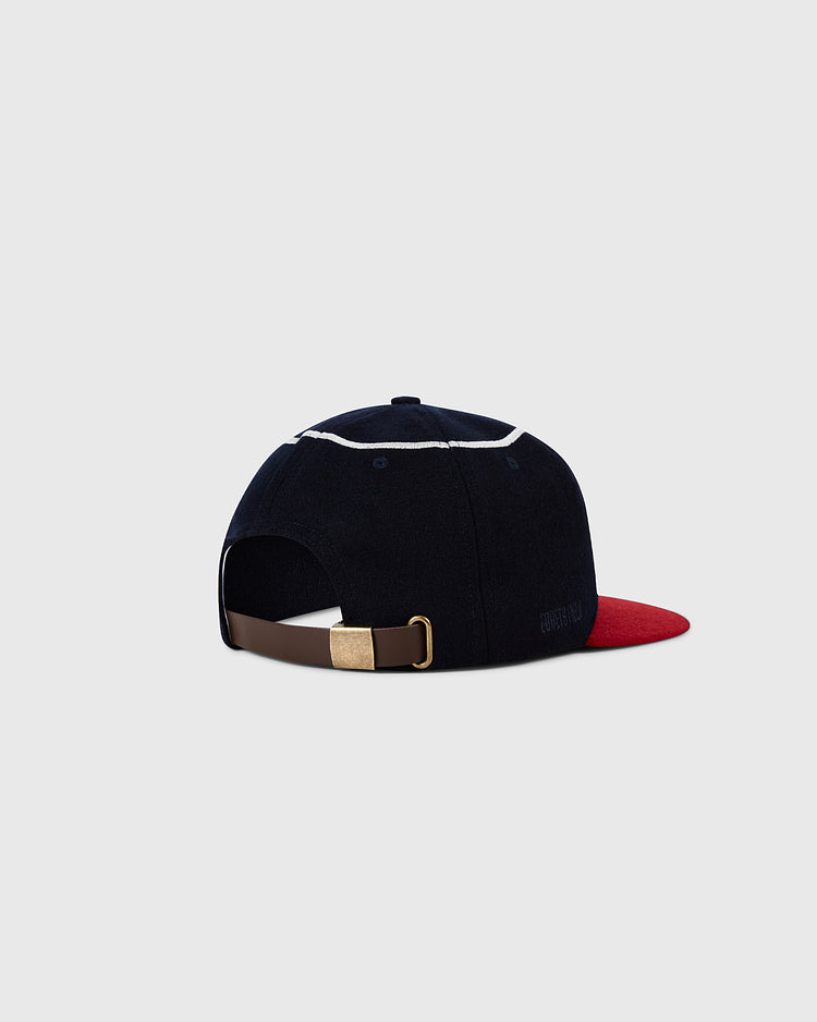 The Ebbets Field Los Angeles Angels 1961 MLB Authentic Wool Ballcap is navy with a red brim and white piping, shown from the back. Part of the Decade of Change Collection, it features a brown adjustable strap and brass buckle against a grey background.
