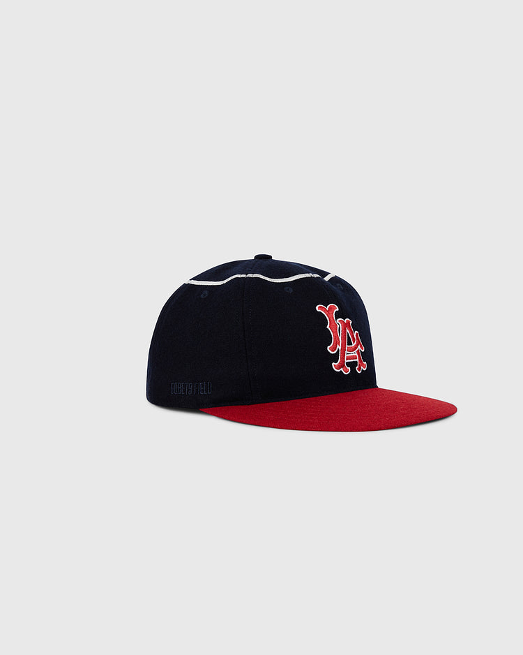 The Ebbets Field Los Angeles Angels 1961 MLB Authentic Wool Ballcap features a black crown, red brim, and a white and red embroidered LA logo on the front, shown against a light gray background.