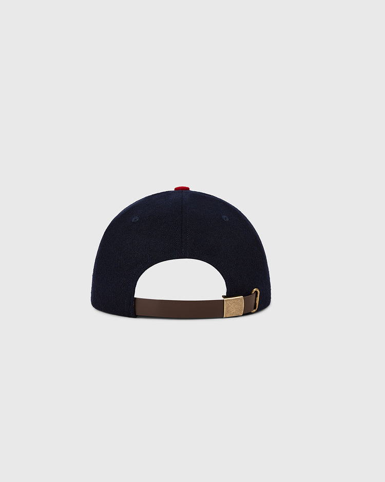 A navy St. Louis Cardinals 1963 MLB Authentic Wool Ballcap by Ebbets Field, shown from the back with a brown adjustable strap, brass buckle, and a red top button against a plain light gray background.