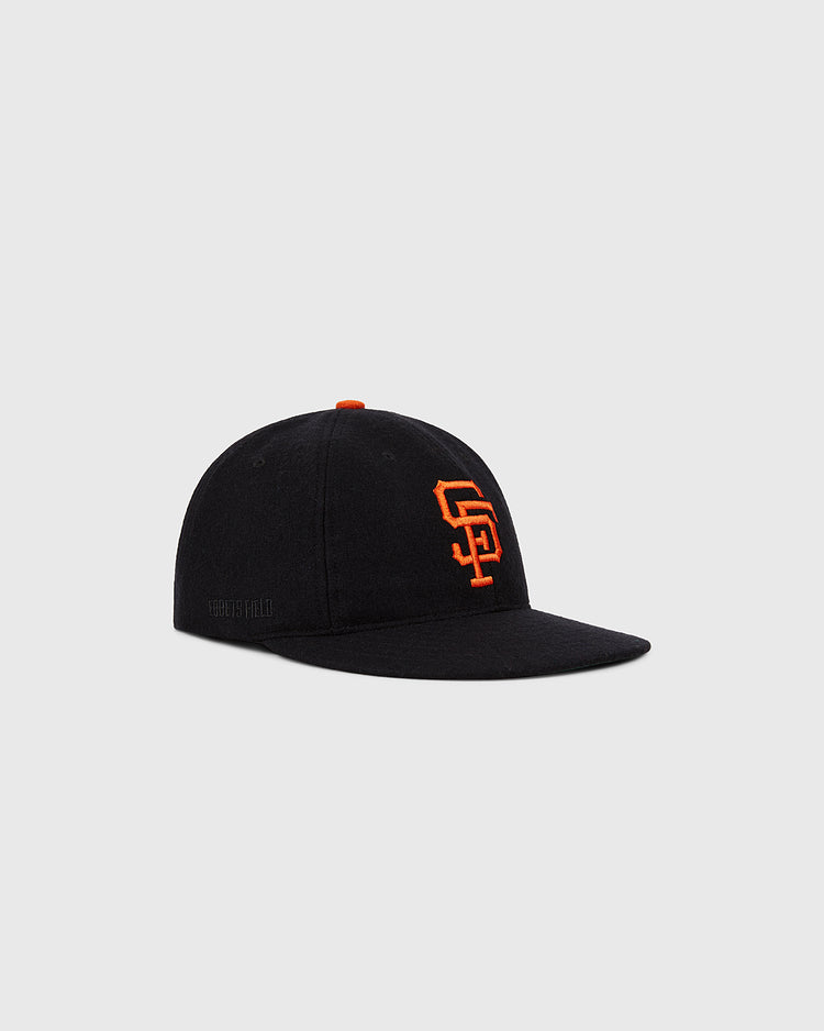 The Ebbets Field San Francisco Giants 1958 MLB Authentic Wool Ballcap is a black cap with an orange SF logo, inspired by the original on-field design, shown on a light gray background.