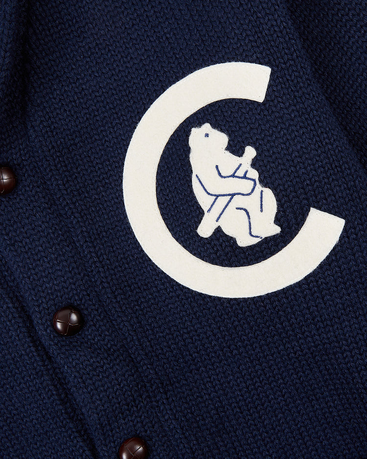 A close-up of the EFF Chicago Cubs 1911 Wool Shawl Collar Sweater in navy blue knit, showing brown buttons and a white C emblem with an outlined bear holding a bat.