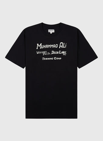 The Ebbets Field Muhammad Ali 'Deer Lake Training Camp' Short Sleeve Graphic Tee features a black design with white 