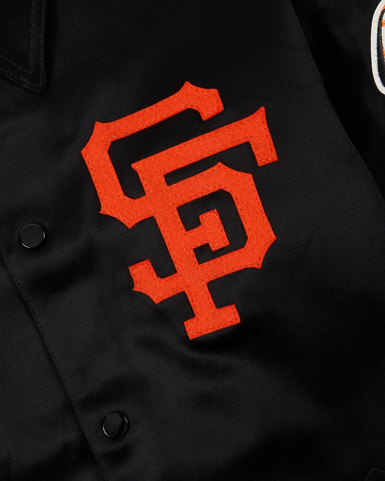 Close-up of the EFF San Francisco Giants 1958 Satin Windbreaker Jacket, featuring large orange interlocking SF letters stitched on and matte black snaps on the left side.