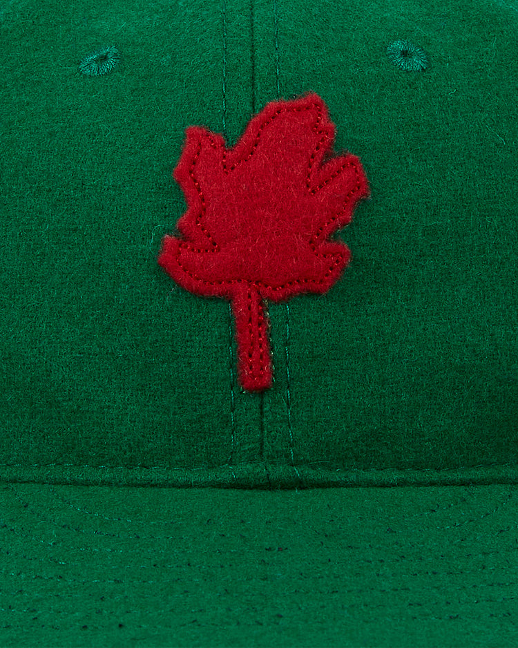 A close-up of the EFF Oakland Oaks 1939 Authentic Wool Ballcap in green, showing a red felt maple leaf patch, detailed stitching, and vintage-style wool fabric inspired by classic Pacific Coast League teams.