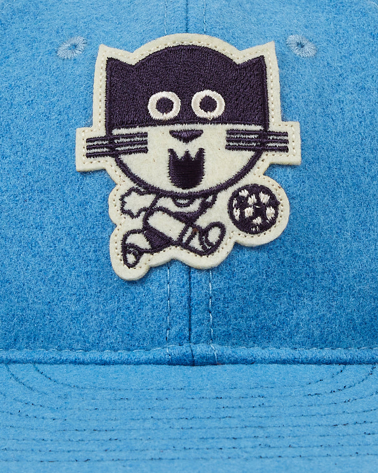 The EFF Chicago Cats 1976 Authentic Wool Ballcap features a blue design with an embroidered cartoon cat playing soccer, inspired by the American Soccer League team's fun spirit, and includes a black-and-white soccer ball patch.