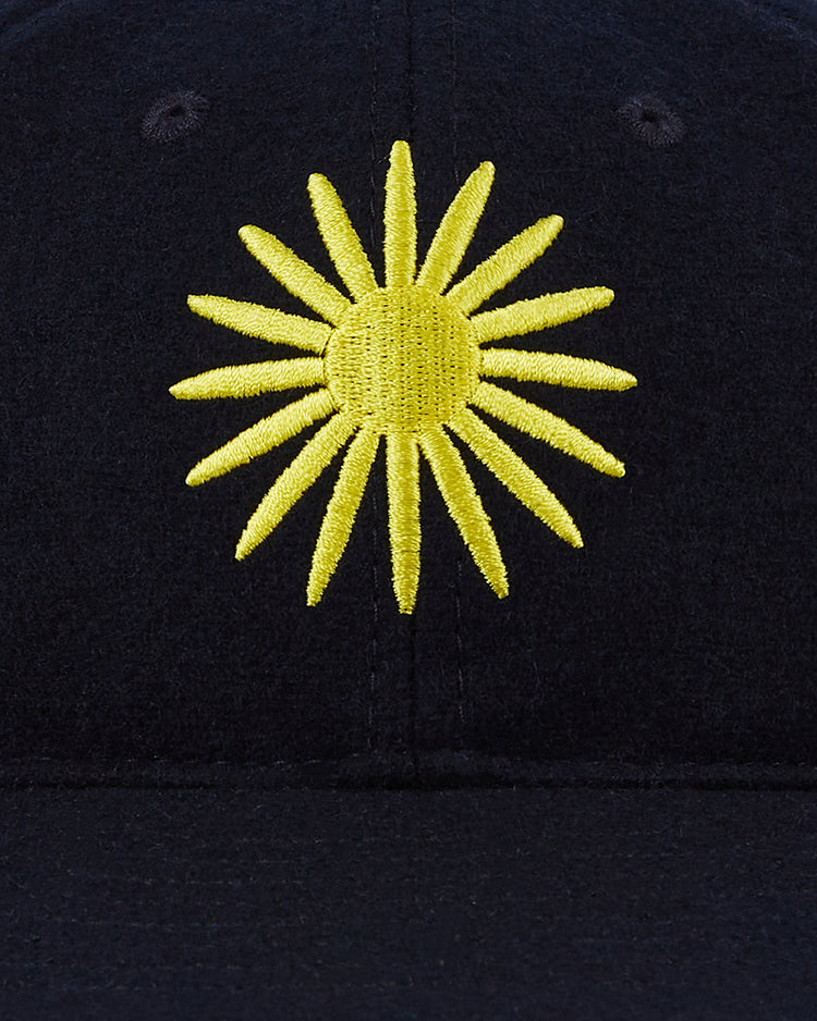 The Darby Daisies 1932 Authentic Wool Ballcap by EFF is a black cap featuring a bright yellow embroidered sunburst on the front, inspired by Negro League iconography.