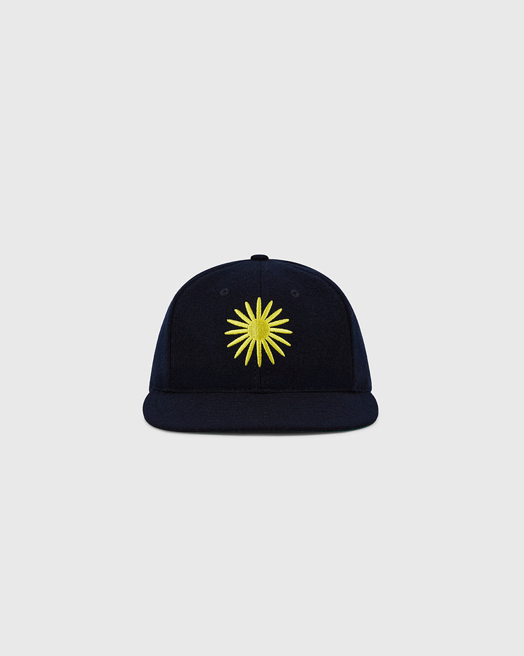 The EFF Darby Daisies 1932 Authentic Wool Ballcap features a navy blue design with a yellow sunburst embroidered on the front, inspired by the historic Hilldale club, shown on a plain light gray background.