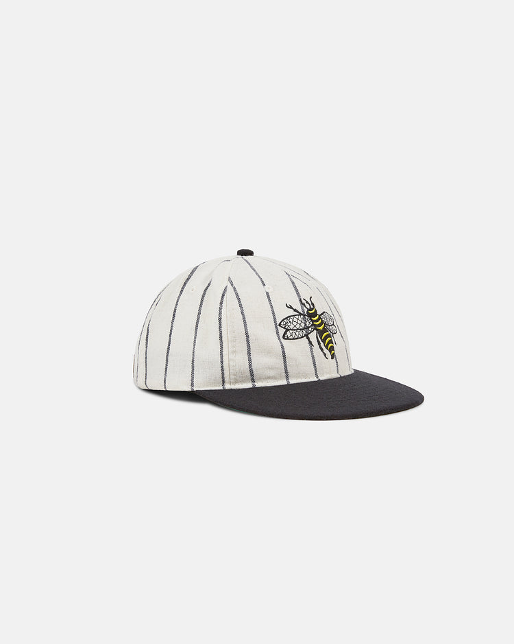 The EFF Chicago Cats 1976 Authentic Wool Ballcap features a white crown with thin black stripes, a black brim, and an embroidered yellow bee logo inspired by the classic soccer team’s original design.