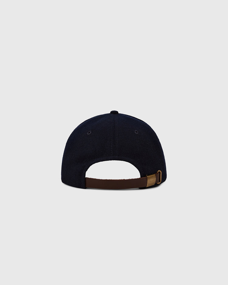 The Ebbets Field Ebbets Felt 'E' Wool Ballcap is a black vintage cap shown from the back, with a brown adjustable strap and brass buckle, crafted from wool broadcloth and displayed on a plain light gray background.