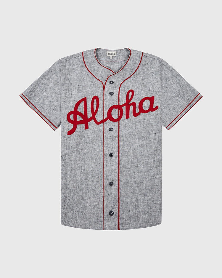 The Ebbets Field Aloha 100th Infantry 1942 Authentic Wool Road Baseball Jersey features gray wool, red piping, and the classic Aloha script logo across the chest, inspired by the famed Aloha Team and 100th Infantry Battalion.