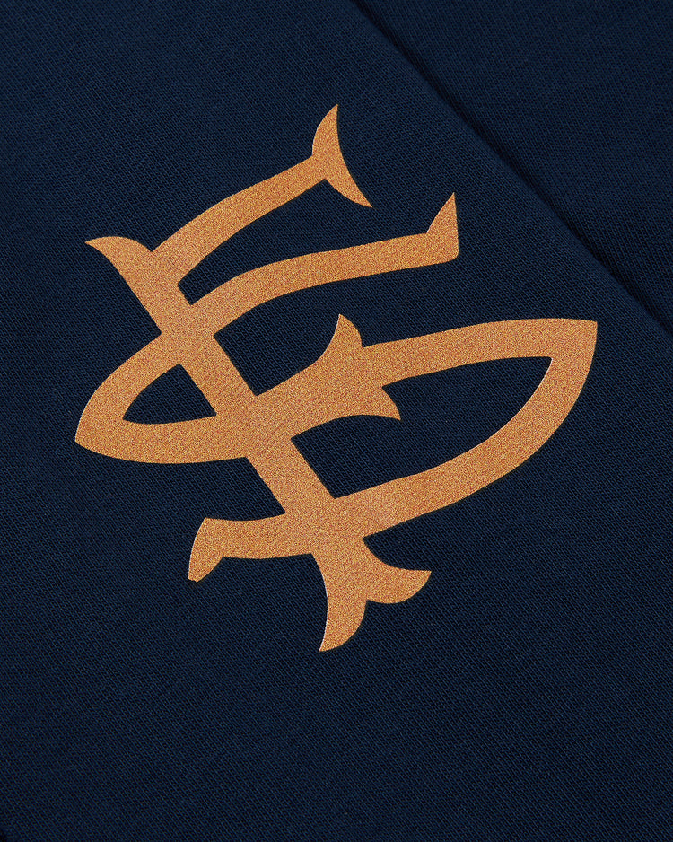 A close-up of the Ebbets Field San Francisco Seals (PCL) Long Sleeve Graphic Tee, showcasing bold gold interlocking letters inspired by the Pacific Coast League team's classic monogram on dark blue fabric.