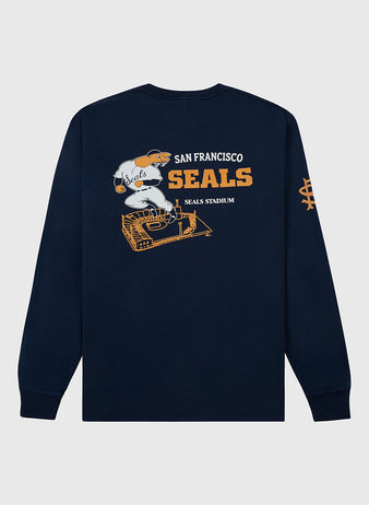 The Ebbets Field San Francisco Seals (PCL) Long Sleeve Graphic Tee features a navy blue design with a baseball player in a Seals uniform above a stadium graphic. “San Francisco Seals” and “Seals Stadium” appear in orange and white text.