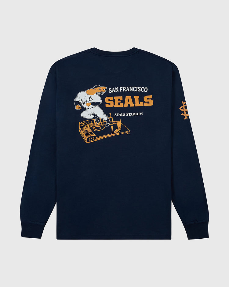 The Ebbets Field San Francisco Seals (PCL) Long Sleeve Graphic Tee features a navy blue design with a baseball player in a Seals uniform above a stadium graphic. “San Francisco Seals” and “Seals Stadium” appear in orange and white text.