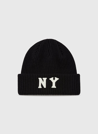 The Ebbets Field New York Black Yankees Felt Logo Ribbed Beanie is a black knit hat with a folded brim and bold white NY letters on the front, shown on a plain light gray background.