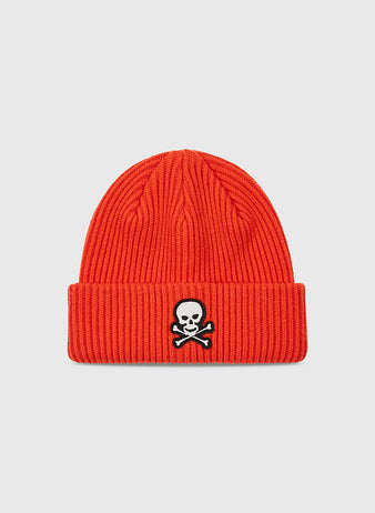 The Ebbets Field Sioux City Ghosts Embroidered Felt Ribbed Beanie features a bold red color, ribbed folded brim, and white embroidered skull and crossbones inspired by the fast-pitch softball team. Set against a plain light gray background.