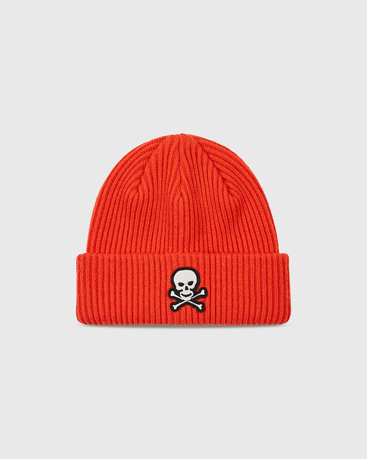 The Ebbets Field Sioux City Ghosts Embroidered Felt Ribbed Beanie features a bold red color, ribbed folded brim, and white embroidered skull and crossbones inspired by the fast-pitch softball team. Set against a plain light gray background.