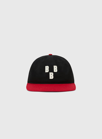 The Ebbets Field Birmingham Black Barons 1948 Cotton Twill Ballcap features a black crown, red brim, and three vertical white “B”s on the front, inspired by the historic Negro Leagues team, shown on a light gray background.