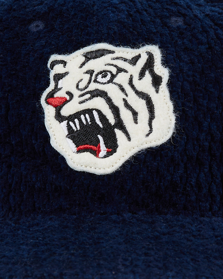 A detailed white tiger patch with black and red accents is sewn onto the Osaka Tigers Japanese Indigo Corduroy Ballcap by Ebbets Field, an heirloom cap inspired by the proud Osaka Tigers.