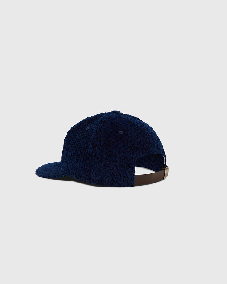 The Ebbets Field Osaka Tigers Japanese Indigo Corduroy Ballcap is shown from the back, displaying its textured navy blue finish, brown adjustable strap, and curved brim against a plain light gray background.