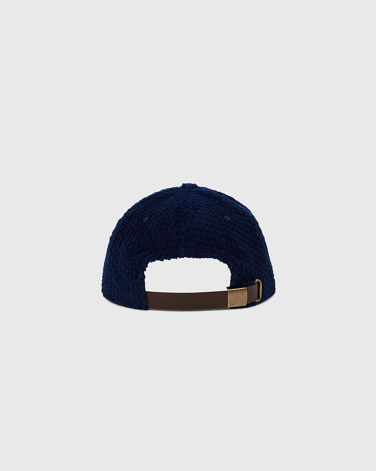 The Osaka Tigers Japanese Indigo Corduroy Ballcap by Ebbets Field is shown from the back, highlighting its navy blue indigo-dyed corduroy, brown adjustable strap with gold buckle, and a plain light gray background.