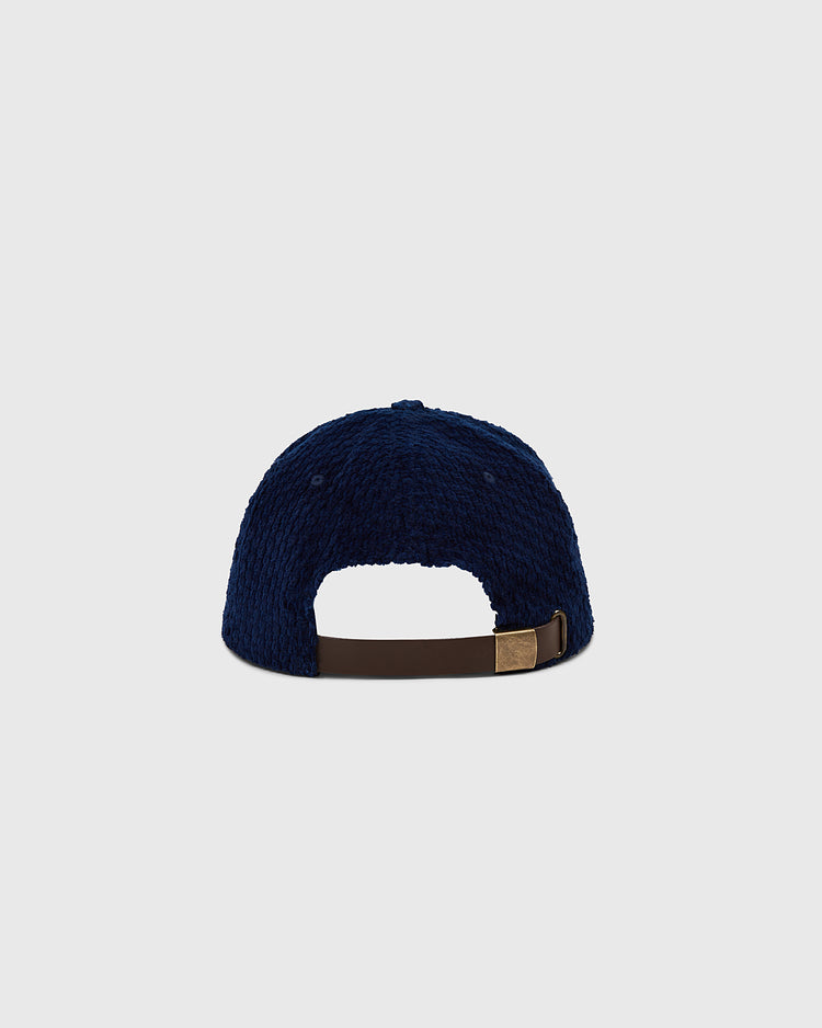 The Ebbets Field Tokyo Giants Japanese Indigo Corduroy Ballcap is shown from the back, featuring navy blue textured fabric and a brown adjustable strap with metal clasp, set against a plain light gray background.
