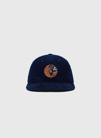 The Ebbets Field Hiroshima Carp Japanese Indigo Corduroy Ballcap, a navy blue hat with an embroidered gold fish on the front, is displayed against a plain light gray background.