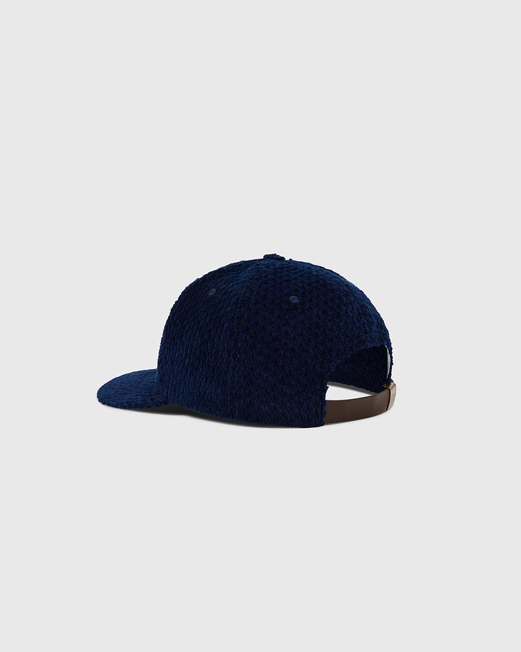 The Ebbets Field Hiroshima Carp Japanese Indigo Corduroy Ballcap, shown from the back and side, features navy blue indigo-dyed corduroy, a brown adjustable strap, and a curved brim against a light gray background.