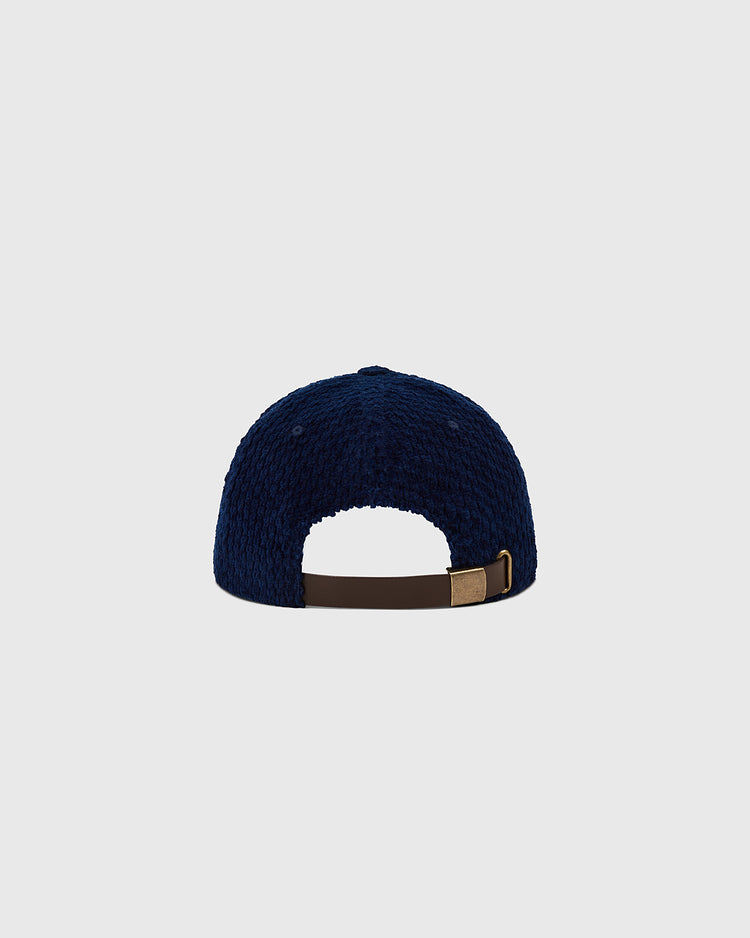 The Ebbets Field Hiroshima Carp Japanese Indigo Corduroy Ballcap, shown from the back, displays its navy corduroy texture and a brown adjustable strap with metal clasp against a plain light grey background.