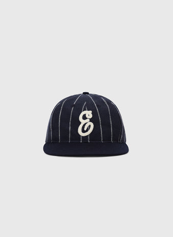 The Ebbets Field Ebbets Felt 'E' Wool Pinstripe Ballcap features navy blue wool broadcloth, thin white pinstripes, and a white embroidered letter E on the front, shown against a plain light gray background.