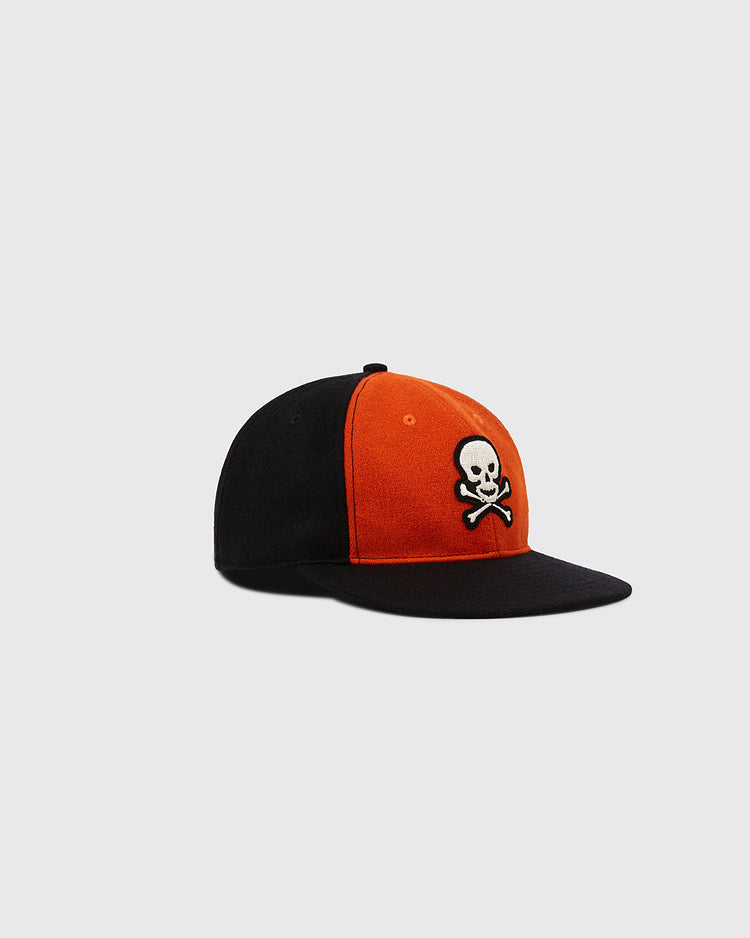 The EFF Sioux City Ghosts 1935 Authentic Wool Softbrim Ballcap features a black and orange design with a white skull and crossbones logo, evoking vintage style, displayed on a plain light grey background.